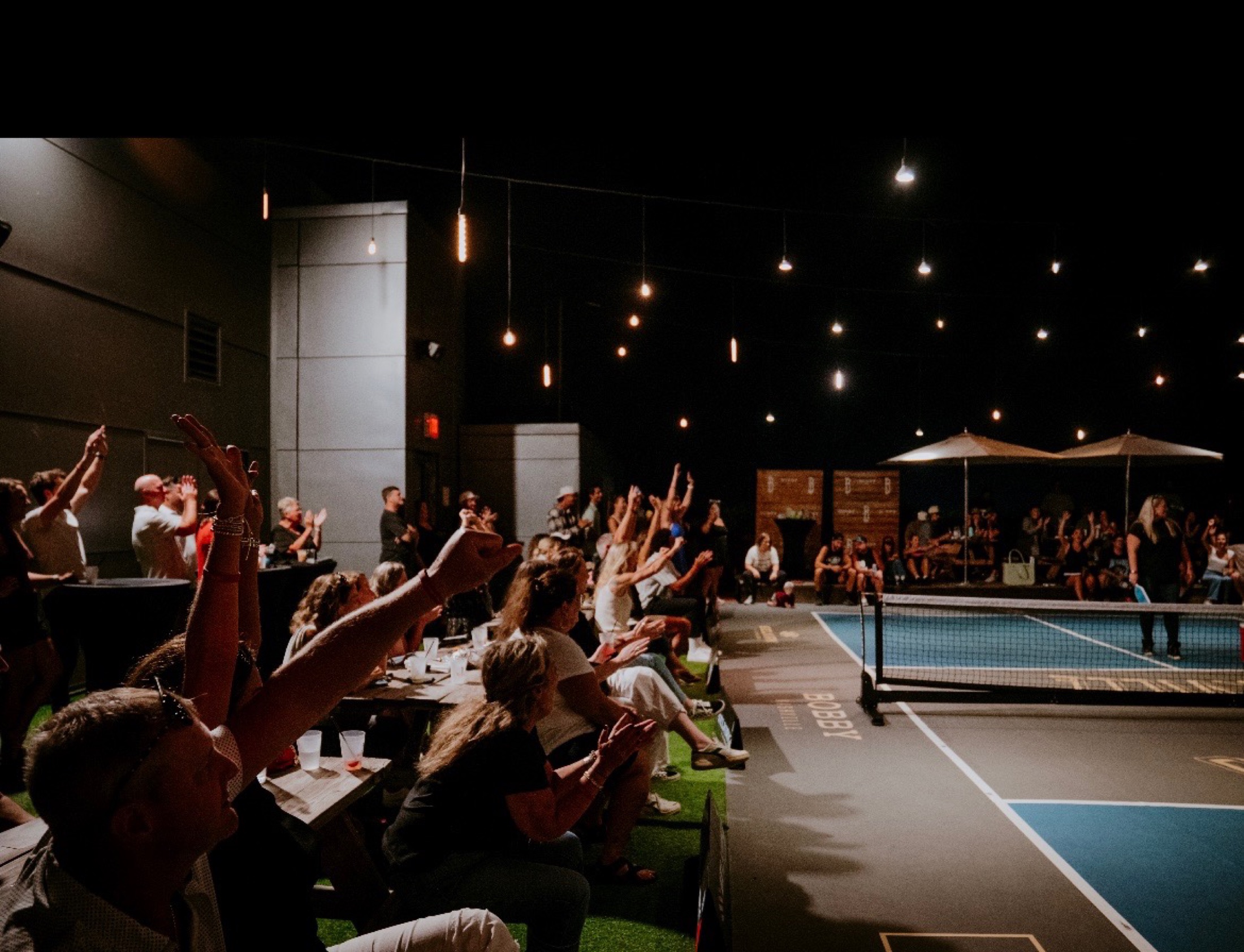 A lively crowd surrounding the Bobby Hotel rooftop court